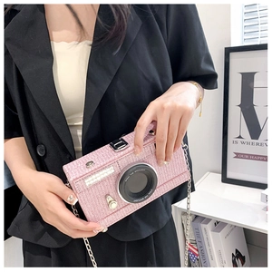 Close-up of pink tweed camera-shaped crossbody bag with silver chain strap and metal clasp