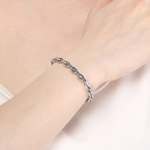 Silver stainless steel oval link bracelet with stylish pig nose clasp on model wrist