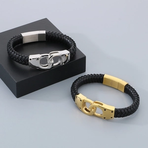 Detail view of woven black leather bracelets with gold and silver handcuff-style clasps