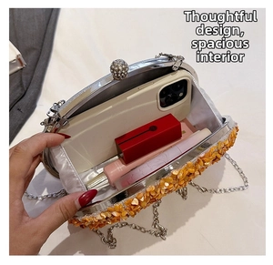 Detail of the orange evening clutch interior showing space for phone and lipstick
