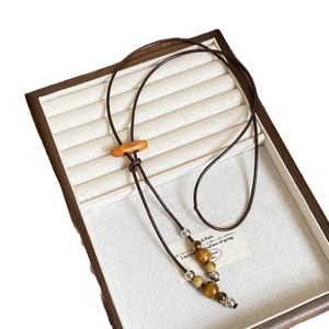Long collier bohème avec perles en céramique et glands en bois sur cordon en cire ajustable
