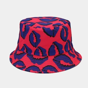 Dettaglio del motivo a labbra rosse e blu sul cappello a secchiello double-face