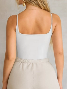 Back view of a white Y2K knitted camisole featuring thin straps and a square back neckline