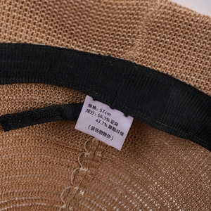 Detailed close-up of linen knit sun hat interior showing 57cm size label and fabric tag