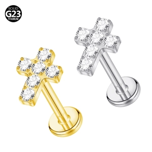 Detailed macro of gold and silver G23 titanium cross stud earrings with zircon stones