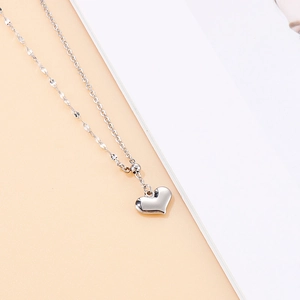 Dettaglio della collana in titanio con ciondolo a cuore argento e finitura a specchio