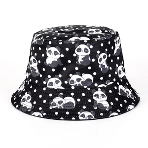 Detail shot of the black bucket hat featuring white polka dots and panda cartoon prints
