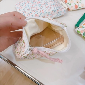 Detail view of mini floral cotton pouch showing inner lining and cosmetic storage