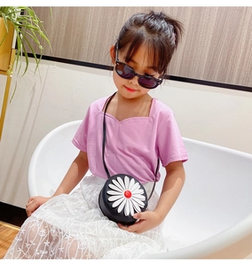 Detailed view of kids daisy crossbody bag worn by a young model in a pink outfit