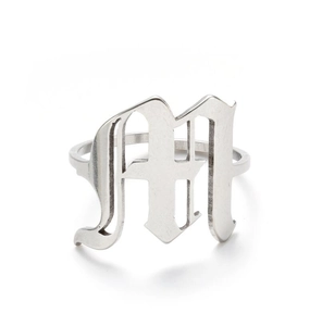 Detailed close-up of a silver Gothic letter M open ring with a vintage industrial finish
