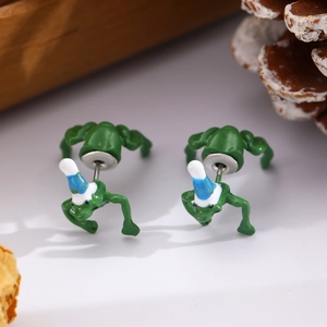 Close-up of green cartoon frog earrings wearing blue hats for Christmas parties