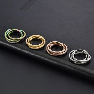 Detailed interlocking rings in gold, rose gold, and silver with frosted matte finish