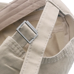 Detail of adjustable metal buckle and stitching on khaki cotton baseball cap