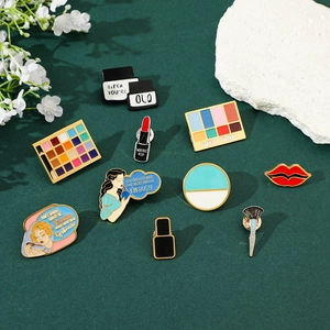 Macro shot of colorful makeup enamel pins with creative eyeshadow and lipstick designs