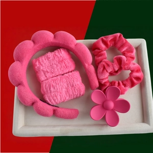 Detail view of 6-piece pink plush headband set with flower claw clip and velvet scrunchies