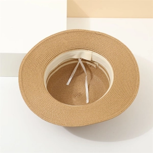 Macro detail of khaki straw hat featuring woven texture and adjustable inner white sweatband