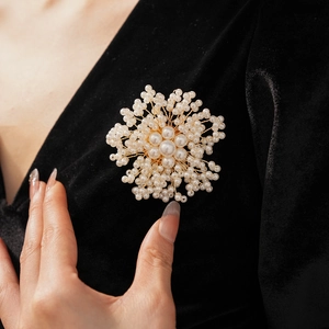 Detailed view of handmade woven pearl flower brooch pinned on black velvet fabric
