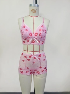 Detailansicht des rosa Spitzen-Lingerie-Sets mit roten Lippen und Schleifen