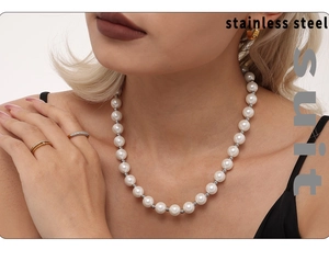 Detail of stainless steel suit with 12mm shell pearl necklace and golden ring set