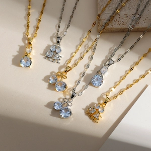 Flat lay of delicate cherry pendants and gold necklaces on textured background