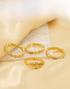 Detailed close-up of 18k gold plated stainless steel rings with bee and twisted designs