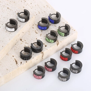 Detail of colorful crystal paved stainless steel huggie earrings on stone display