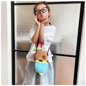Kid modeling a plush capybara crossbody bag featuring brown and sky blue patchwork design