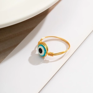 Detailed view of handmade gold wire wrapped ring featuring a blue evil eye opal bead