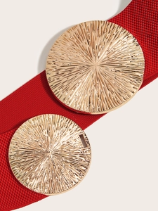 Close-up of bright red elastic waist belt with large gold radial textured metal buckles