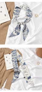 Detail of blue and white silk scarf showing stitching, alphabet prints and wash label
