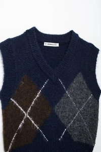 Detail der Argyle-Strickweste mit V-Ausschnitt und dunkelblauem Rautenmuster