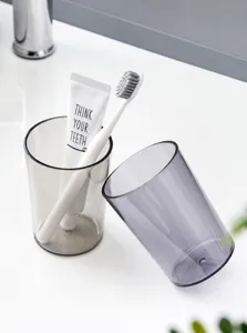 Detail of minimalist translucent grey and brown mouthwash cups on a bathroom vanity