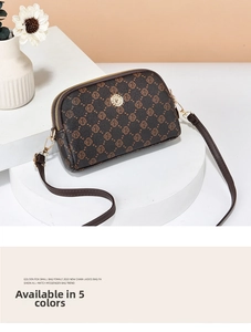 Close-up of rose print crossbody bag with dual golden zippers and metallic emblem