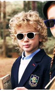Vintage round frame sunglasses for kids worn by a child model in a woodland setting