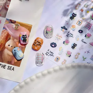 Macro detail of embossed nail stickers featuring cute cats, flowers, and checkered patterns