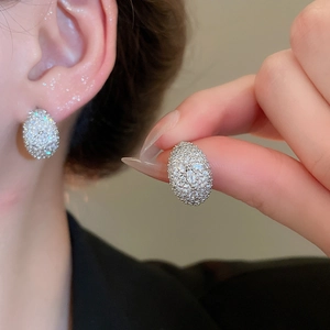 Macro detail of silver moon earrings featuring pave-set cubic zirconia and a polished finish
