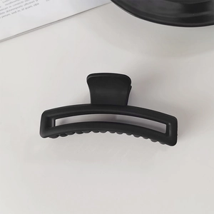 Détail d'une pince à cheveux rectangulaire noire mate pour coiffer les cheveux épais