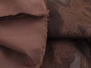 Macro de tissu brun avec motifs jacquard floraux élégants et coutures de bordure soignées