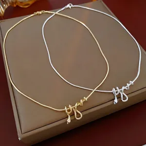 Elegant gold and silver snake pendant necklaces displayed on a luxury leather jewelry box