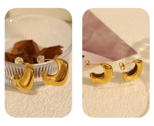 Detailed view of gold plated C-shape hoop earrings with silicone and metal backings