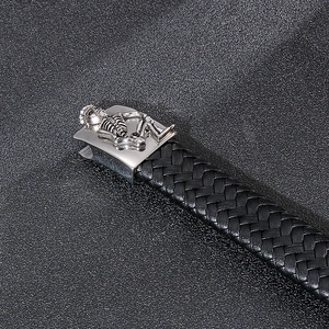 Detail view of black braided leather bracelet with a silver skull magnetic metal clasp