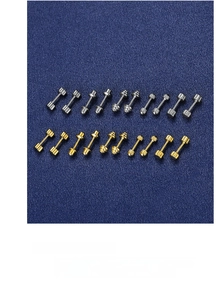 Macro shot of silver and gold screw-back stud earrings on a textured navy background