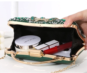 Spacious interior of emerald evening bag with rhinestones, holding phone and lipstick