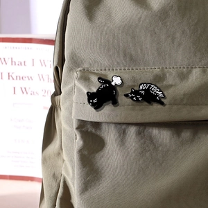 Pins de chat en émail noir avec texte Not Today sur une poche de sac à dos en toile