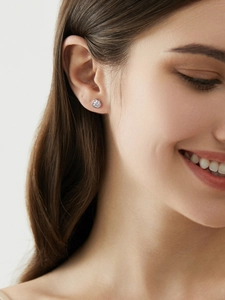 Close-up of sparkling moissanite stud earring in 925 sterling silver worn by model