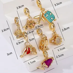 Size comparison chart for gold travel diary charms featuring tower, plane, and luggage designs