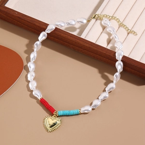 Detail of baroque pearl necklace with golden heart pendant and colorful accent beads