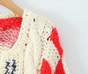 Gros plan sur le pull au crochet fait main montrant des motifs texturés en carrés granny