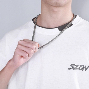 Detail of silver stainless steel hip hop chain necklace showing the V-shaped woven link design