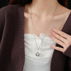 Minimalist titanium steel necklace featuring a polished silver mirror ball pendant on a model